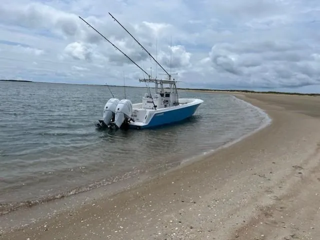 Salt Break Yacht Photos Pics 2020 Contender 32T boat anchored on a sandy beach under cloudy skies.