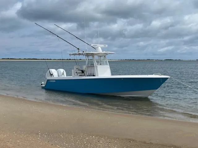 Salt Break Yacht Photos Pics 2020 Contender 32T boat anchored on a sandy beach under cloudy skies.