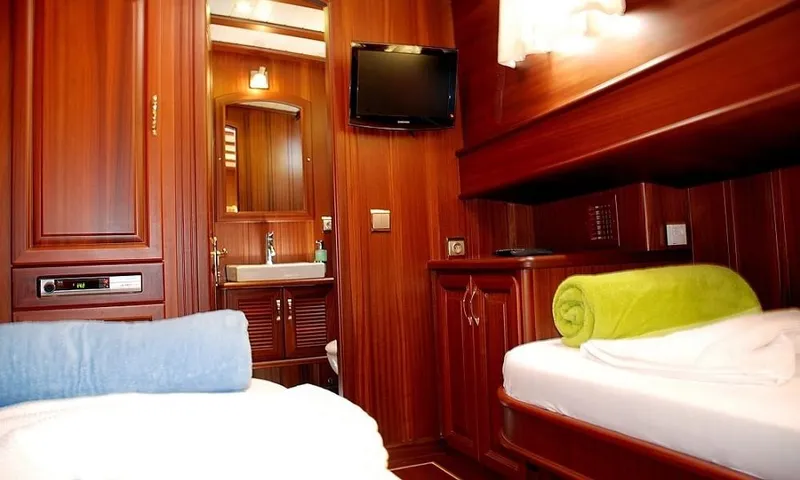  Yacht Photos Pics Luxurious cabin interior of 2009 Custom Made Motorsailor with wooden finish and cozy bedding.