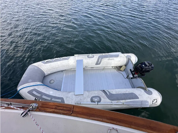 Next Course Yacht Photos Pics Inflatable dinghy moored beside 2001 Island Packet 320 sailboat on calm water.