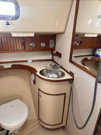 Next Course Yacht Photos Pics 2001 Island Packet 320 yacht bathroom with sink, toilet, and mirror.