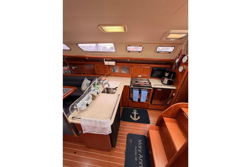 Mary Anne Yacht Photos Pics Interior of 2009 Hunter 38 sailboat kitchen with wooden cabinetry and modern appliances.