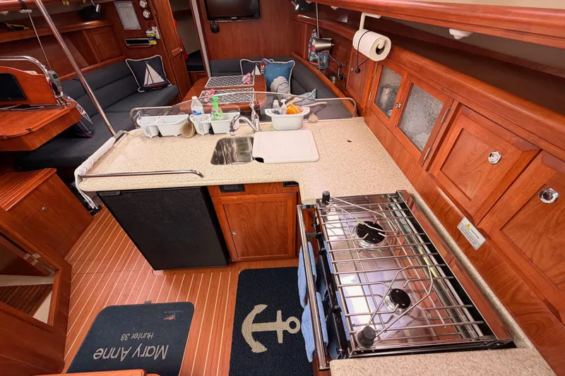 Mary Anne Yacht Photos Pics Interior of 2009 Hunter 38 sailboat featuring a compact kitchen with stove and sink.