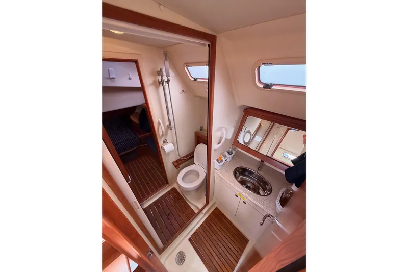 Mary Anne Yacht Photos Pics 2009 Hunter 38 yacht bathroom with shower, toilet, sink, and wooden flooring.
