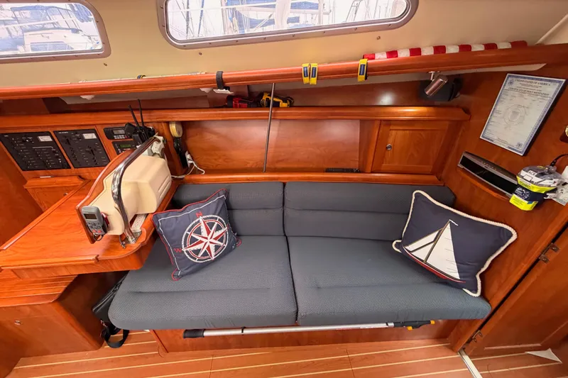 Mary Anne Yacht Photos Pics Cozy interior of 2009 Hunter 38 sailboat with nautical-themed cushions and wooden cabinetry.
