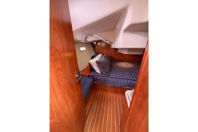 Mary Anne Yacht Photos Pics Cozy cabin interior of 2009 Hunter 38 sailboat with striped bedding and wooden finishes.