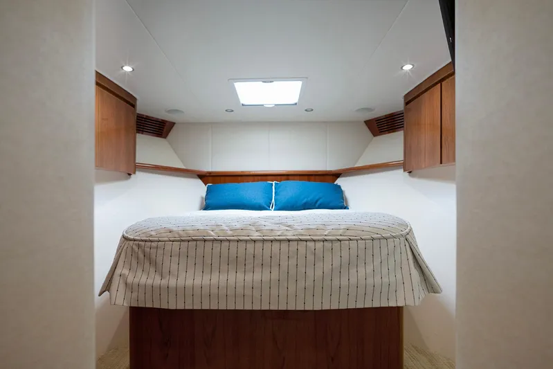 Serenity Now Yacht Photos Pics Luxurious cabin interior of 2014 Viking 66 yacht with cozy bed and wooden cabinets.