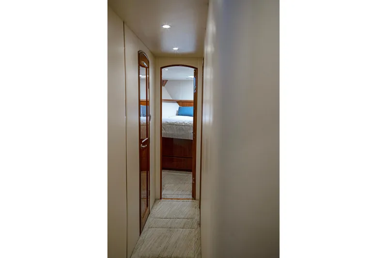 Serenity Now Yacht Photos Pics Narrow hallway inside 2014 Viking 66 yacht, leading to a cozy bedroom.