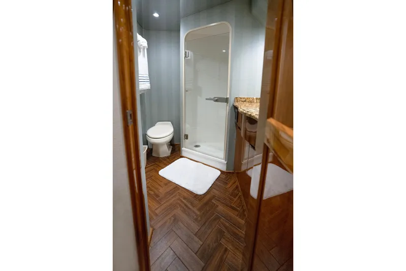 Serenity Now Yacht Photos Pics Luxurious bathroom in 2014 Viking 66 yacht with shower, toilet, and wooden flooring.
