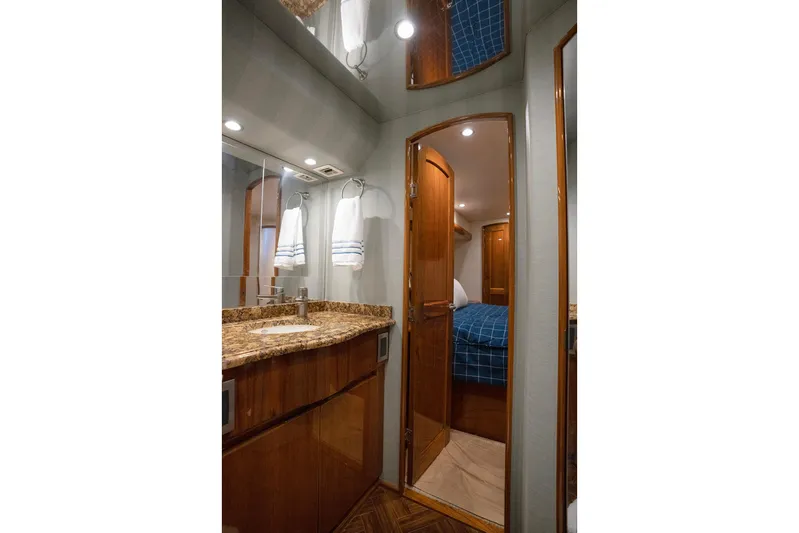 Serenity Now Yacht Photos Pics Luxurious bathroom interior of 2014 Viking 66 yacht with granite countertop and wooden cabinetry.