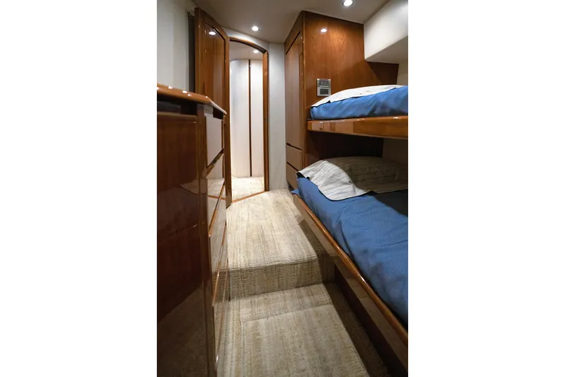 Serenity Now Yacht Photos Pics Interior of 2014 Viking 66 yacht with wooden bunk beds and carpeted floor.