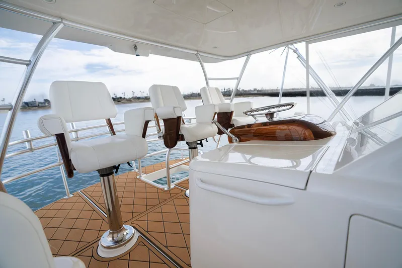 Serenity Now Yacht Photos Pics Luxurious 2014 Viking 66 yacht helm with white seating and wooden accents on open water.