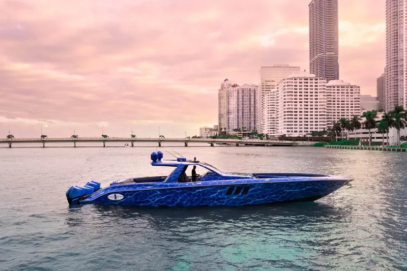  Yacht Photos Pics 2024 Cigarette 59 Tirranna boat on water with city skyline at sunset.