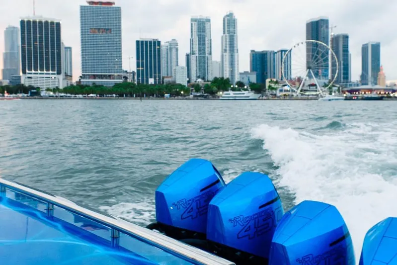  Yacht Photos Pics 2024 Cigarette 59 Tirranna boat cruising near city skyline with Ferris wheel.