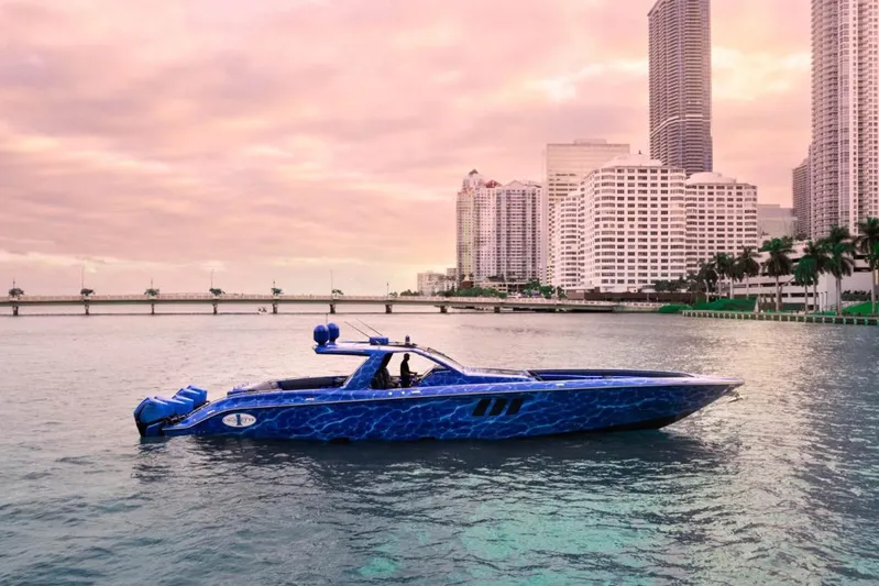  Yacht Photos Pics 2024 Cigarette 59 Tirranna boat on water with city skyline backdrop at sunset.