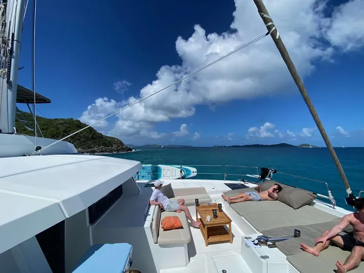 Ad Astra Yacht Photos Pics People relaxing on a Bali 5.4 catamaran, 2020 model, with ocean and island views.