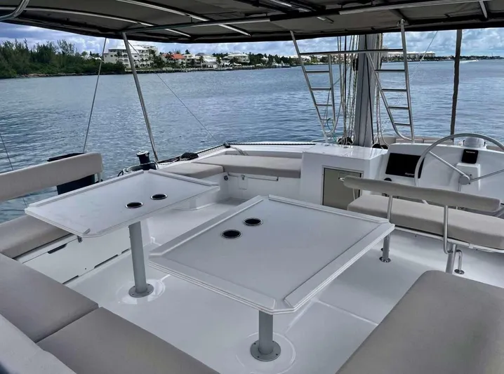 Ad Astra Yacht Photos Pics Luxurious 2020 Bali 5.4 yacht deck with seating and tables, overlooking serene waters.
