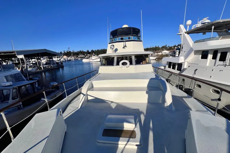 Grand Adventure Yacht Photos Pics 1972 Hatteras 58 Yacht Fisherman docked in a marina under clear blue skies.