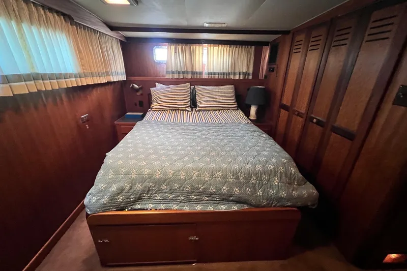 Grand Adventure Yacht Photos Pics Cozy bedroom in 1972 Hatteras 58 Yacht Fisherman with wood paneling and nautical decor.