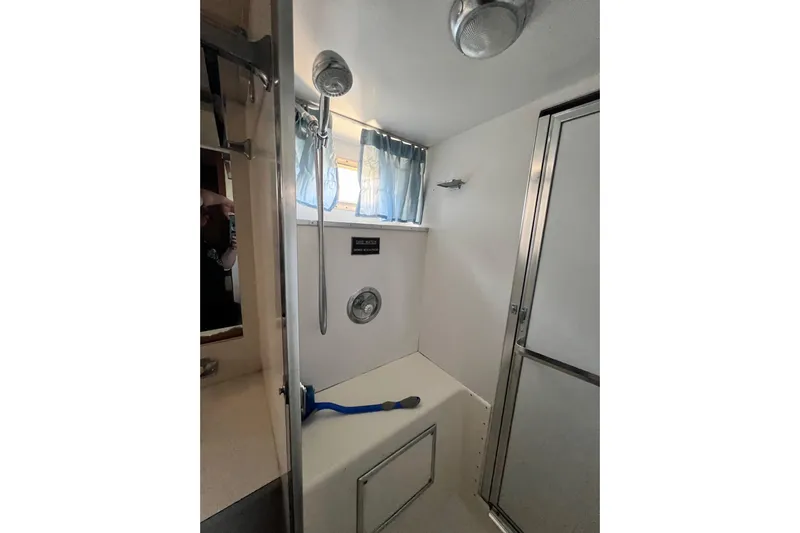 Grand Adventure Yacht Photos Pics 1972 Hatteras 58 Yacht Fisherman bathroom with shower, blue curtain, and modern fixtures.