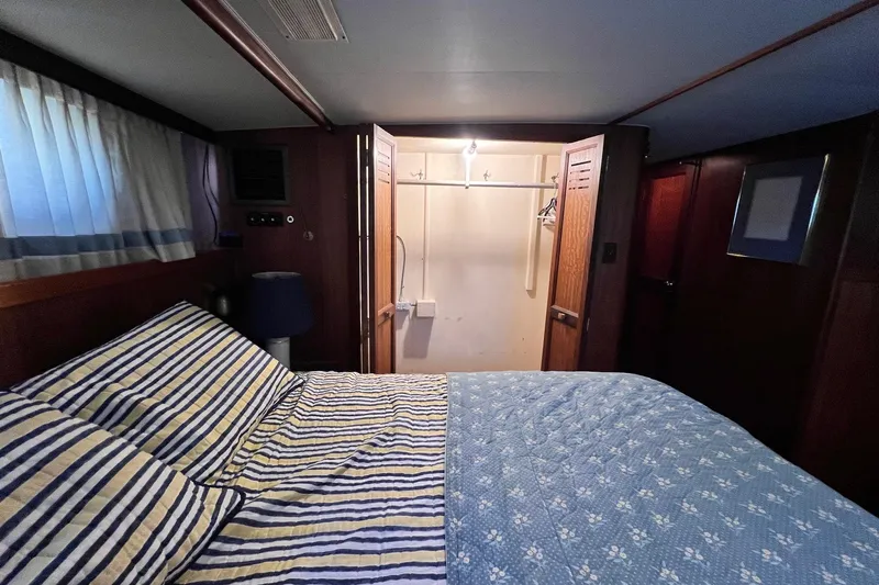 Grand Adventure Yacht Photos Pics 1972 Hatteras 58 Yacht Fisherman cabin with striped bedding and open closet.