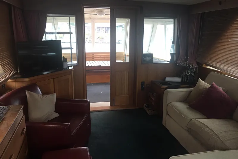 Grand Adventure Yacht Photos Pics Interior of a 1972 Hatteras 58 Yachtfish, featuring cozy seating and a TV.