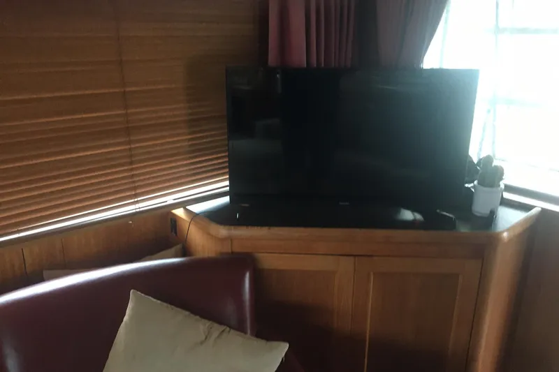 Grand Adventure Yacht Photos Pics Interior of 1972 Hatteras 58 Yachtfish with TV, wooden blinds, and leather seating.