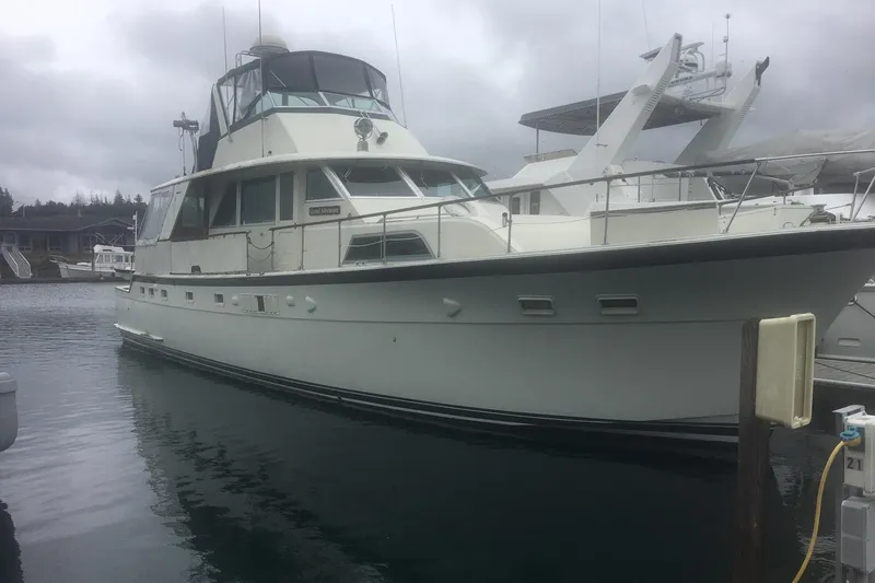 Grand Adventure Yacht Photos Pics 1972 Hatteras 58 Yachtfish docked in a marina under cloudy skies.
