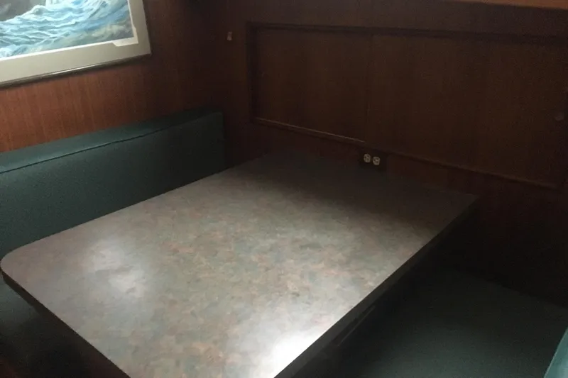 Grand Adventure Yacht Photos Pics 1972 Hatteras 58 Yachtfish interior dining area with wood paneling and cushioned seating.