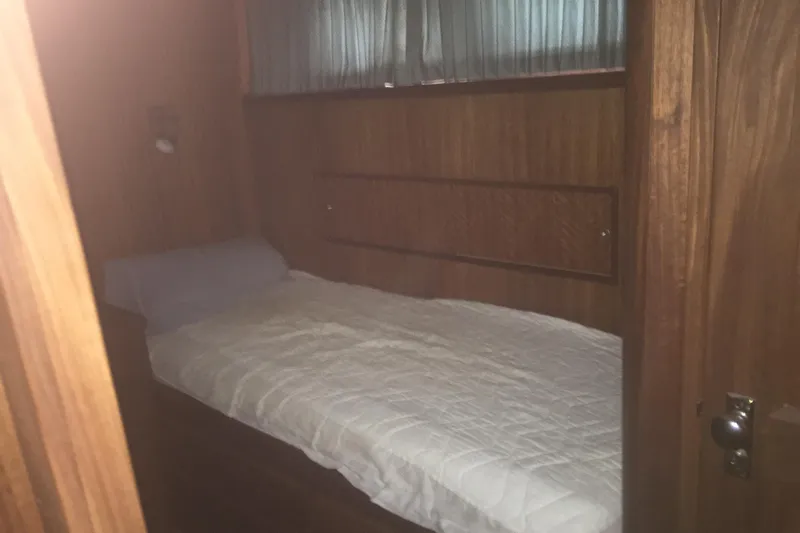 Grand Adventure Yacht Photos Pics 1972 Hatteras 58 Yachtfish cabin with wooden interior and single bed.