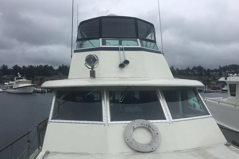 Grand Adventure Yacht Photos Pics 1972 Hatteras 58 Yachtfish docked under cloudy skies.