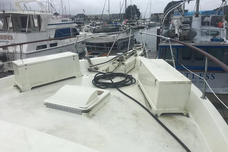 Grand Adventure Yacht Photos Pics 1972 Hatteras 58 Yachtfish deck view at marina, featuring storage boxes and coiled rope.