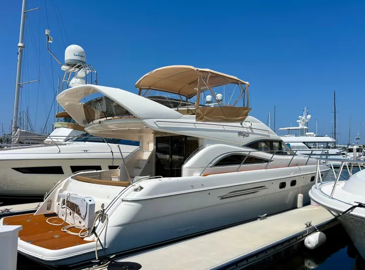 Sea Banshee Yacht Photos Pics 2000 Viking Princess 52 Flybridge yacht docked at marina under clear blue sky.