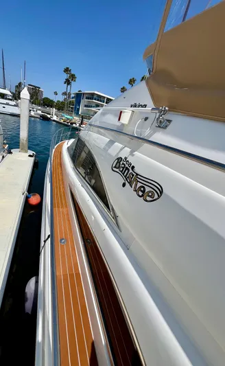 Sea Banshee Yacht Photos Pics Viking Princess 52 Flybridge yacht docked, showcasing sleek design and elegant wood detailing.