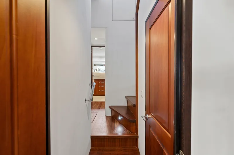 Elsewhere Yacht Photos Pics Interior hallway of 2013 Hatteras 60 Motor Yacht with wooden doors and stairs.