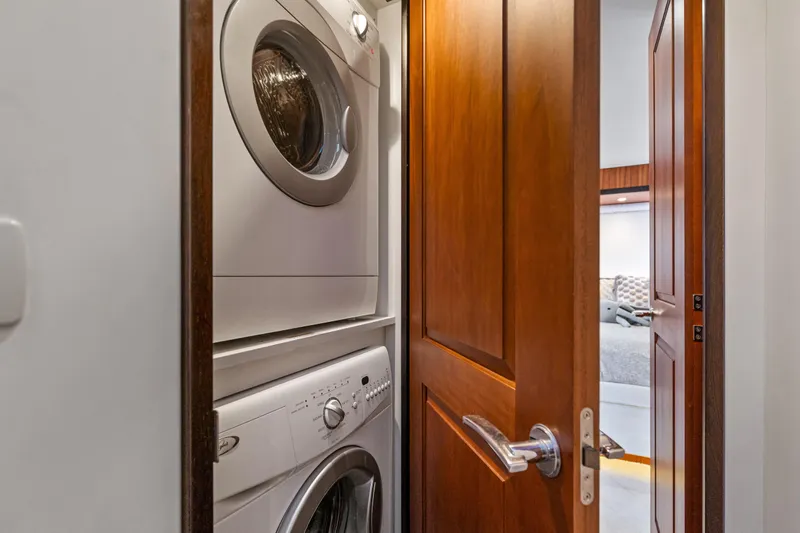 Elsewhere Yacht Photos Pics Laundry area with stacked washer and dryer on 2013 Hatteras 60 Motor Yacht.