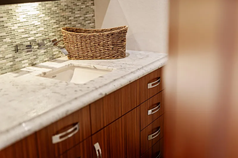 Elsewhere Yacht Photos Pics Luxurious bathroom interior of 2013 Hatteras 60 Motor Yacht with marble countertop and wicker basket.