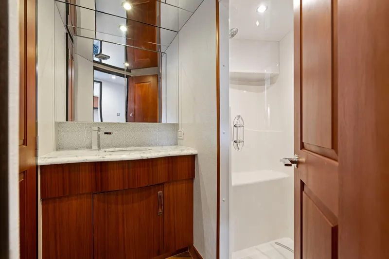Elsewhere Yacht Photos Pics Luxurious bathroom interior of 2013 Hatteras 60 Motor Yacht with wood cabinetry and marble countertop.