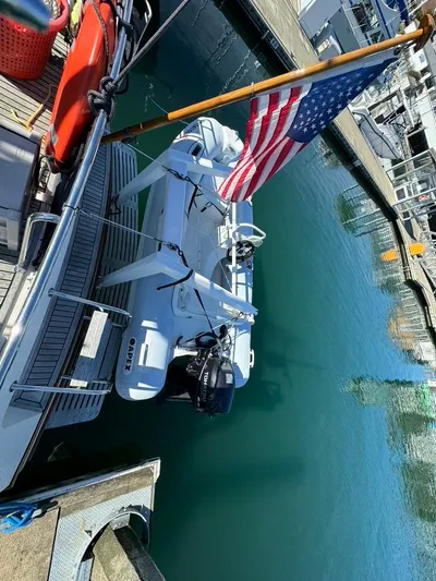  Yacht Photos Pics Grand Banks 42 Motoryacht (1999) docked with American flag and dinghy.