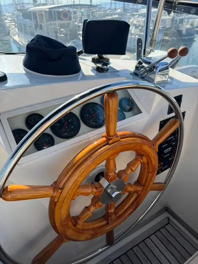  Yacht Photos Pics Wooden steering wheel of a 1999 Grand Banks 42 Motoryacht, with gauges and controls.
