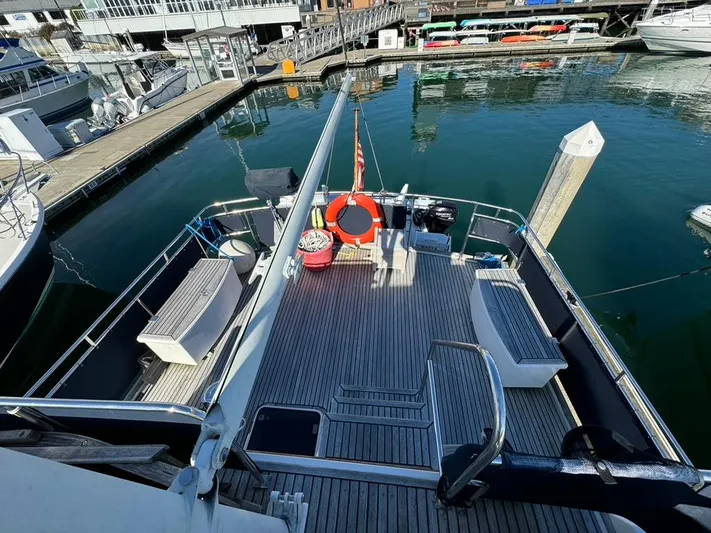  Yacht Photos Pics 1999 Grand Banks 42 Motoryacht docked, featuring spacious deck with seating and safety equipment.