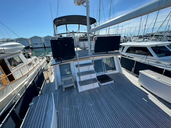  Yacht Photos Pics 1999 Grand Banks 42 Motoryacht with spacious deck, docked at marina under clear blue sky.