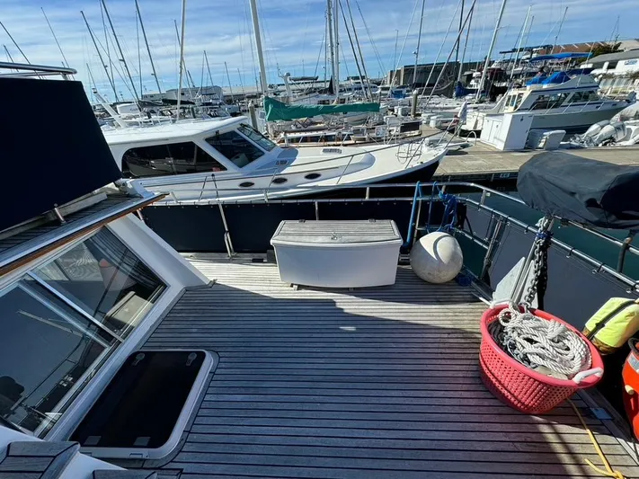  Yacht Photos Pics Deck of 1999 Grand Banks 42 Motoryacht in marina, featuring ropes and storage box.