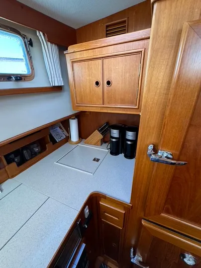  Yacht Photos Pics 1999 Grand Banks 42 Motoryacht kitchen with wooden cabinetry and modern appliances.