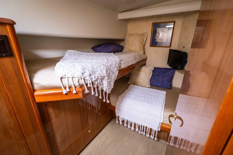  Yacht Photos Pics Cozy cabin interior of 2005 Viking 56 yacht with bunk beds and wooden finish.