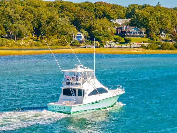 Sadie Ann II Yacht Photos Pics 2005 Ocean Yachts 50 Super Sport cruising on a scenic waterway with lush greenery.