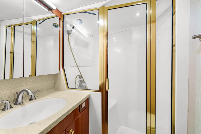Sadie Ann II Yacht Photos Pics Luxurious bathroom in 2005 Ocean Yachts 50 Super Sport with gold accents and modern fixtures.
