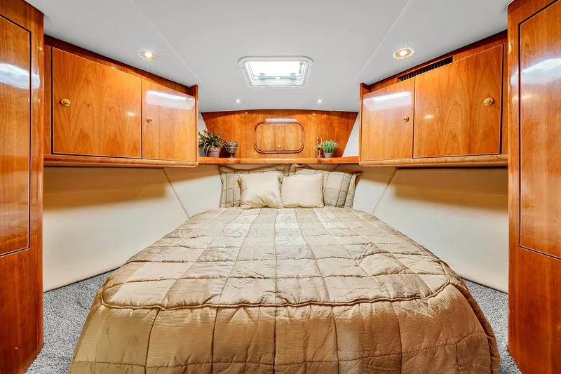 Sadie Ann II Yacht Photos Pics Luxurious cabin interior of 2005 Ocean Yachts 50 Super Sport with wood paneling and cozy bedding.