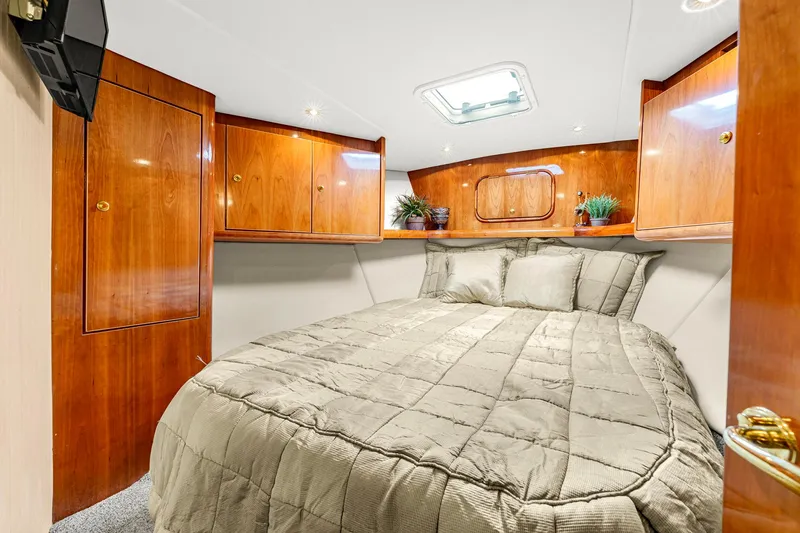 Sadie Ann II Yacht Photos Pics Luxurious cabin interior of 2005 Ocean Yachts 50 Super Sport with wood finish and cozy bedding.