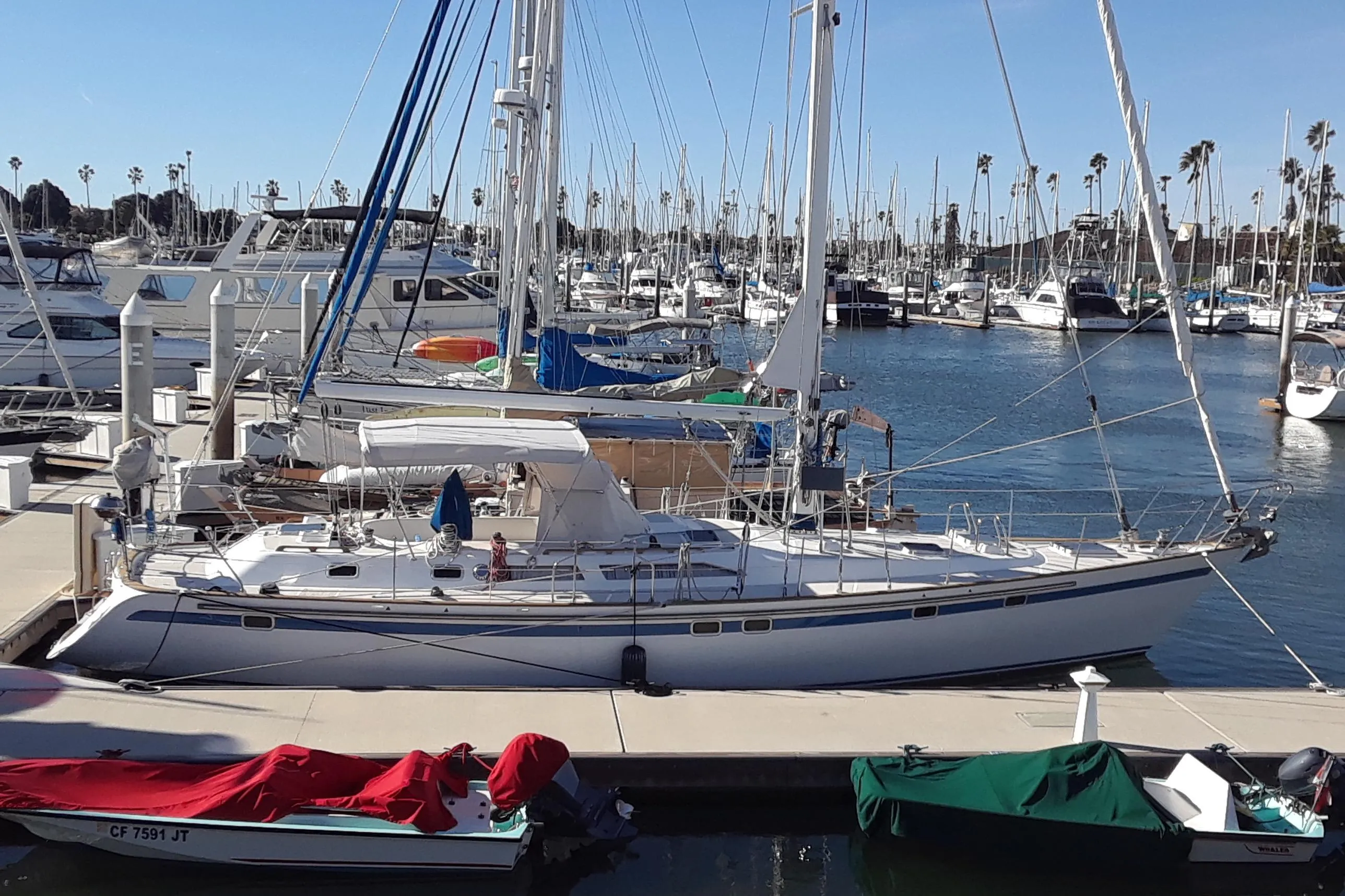 1991 Taswell Sloop docked at a marina, surrounded by other boats and clear blue skies.